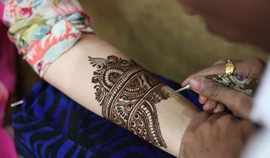 applying mehendi on brides hands-bigindianwedding