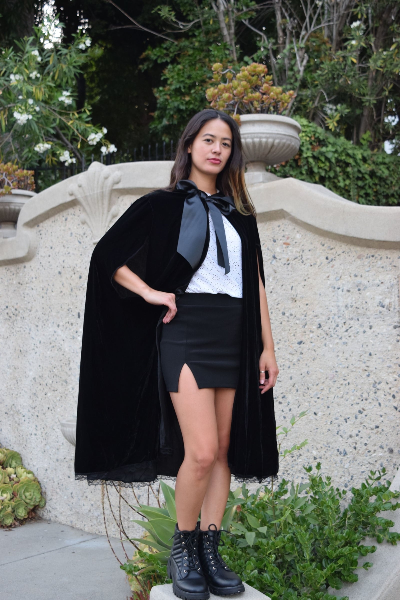 Woman wearing a black cape, illustrating statement outerwear