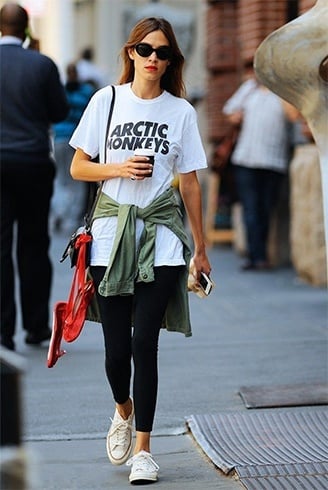 Premium AI Image | A woman wears a white t - shirt with black leggings and  a white t - shirt.