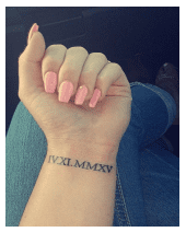 Roman numerals tattooed on the wrist lettering style